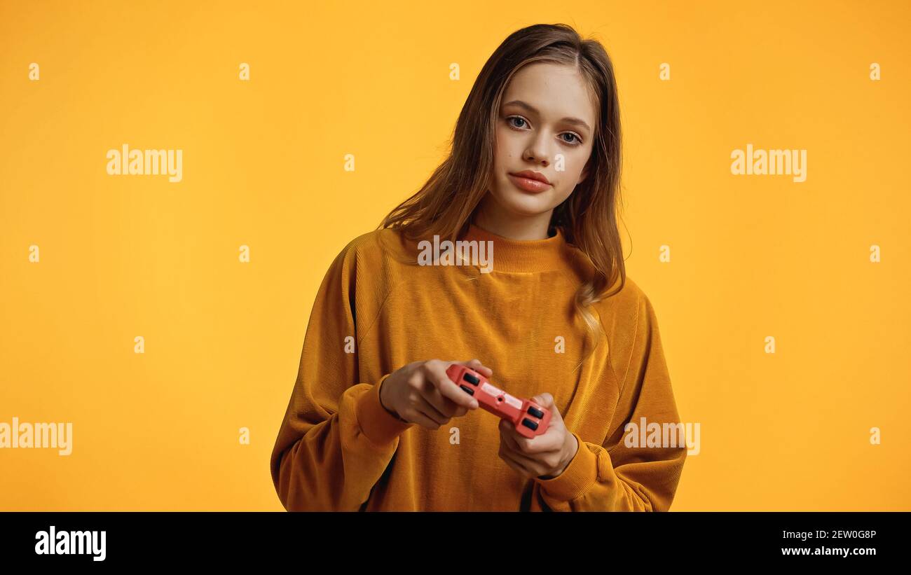 KYIV, UKRAINE - FEBRUARY 24, 2021: teenage girl playing video game isolated  on yellow Stock Photo - Alamy