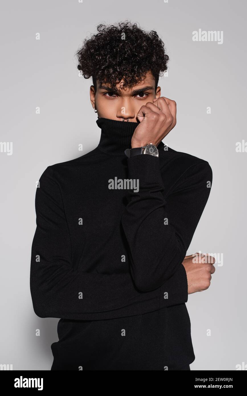 curly african american man covering face with collar of black ...