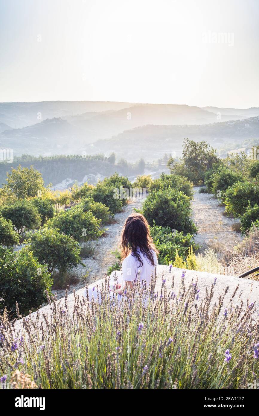 View from a little hillside village in Cyprus, overlooking hills with morning mist in the distance. Woman  looking overlooking in the distance. Stock Photo
