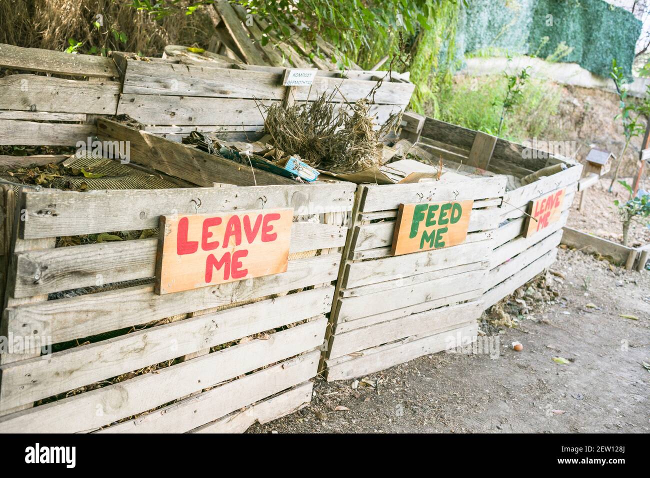 Three wooden compost bin containers with the wording'leave me'  'Feed me' and 'leave me' Stock Photo