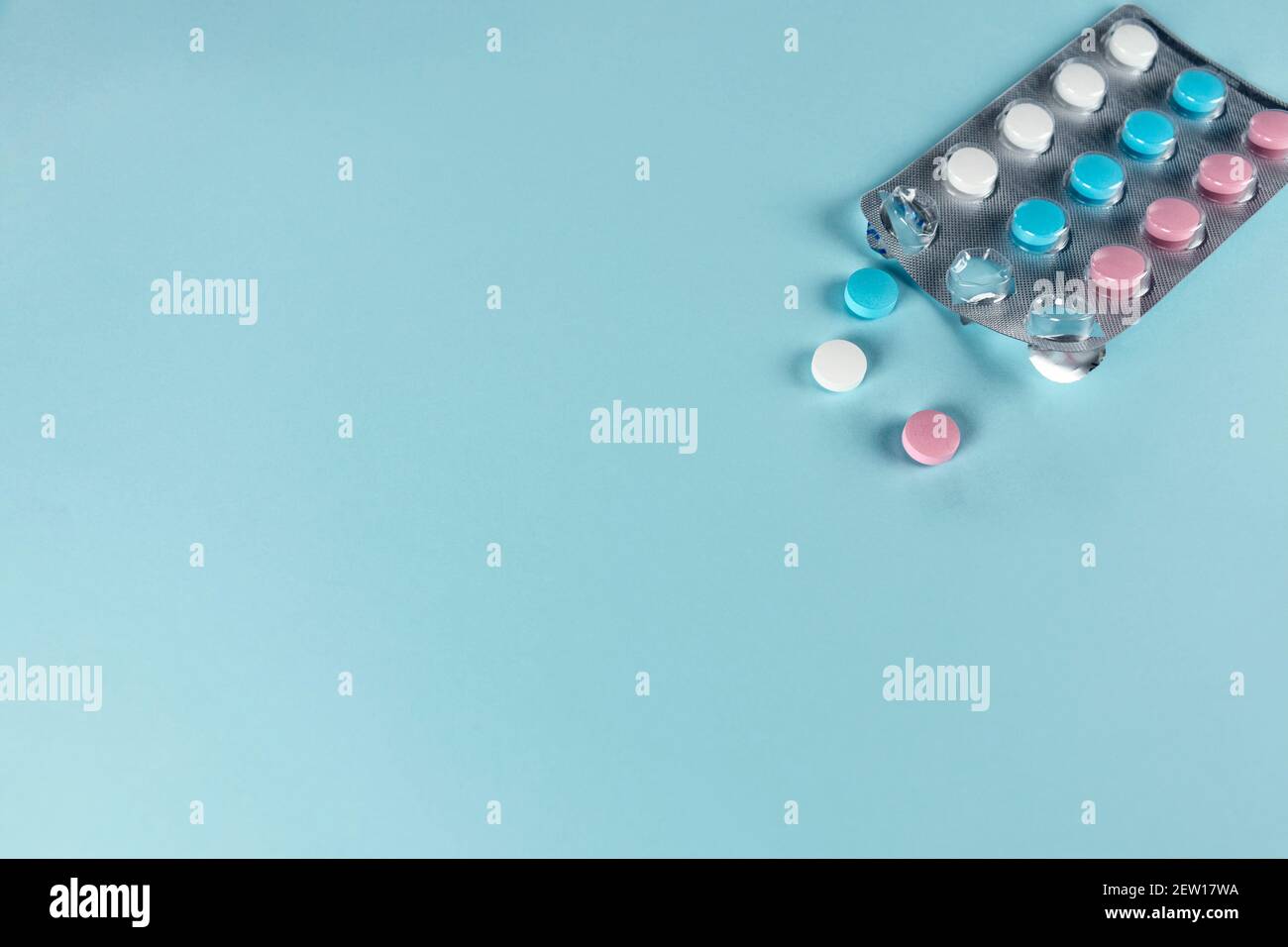 Medicines and pills. Blue, pink and white pills. Multicolored medicines on a pastel blue background. Copy space Stock Photo