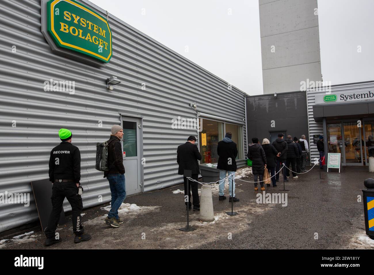 People queue at the wine and liquor store during the Corona Pandemic. Stock Photo