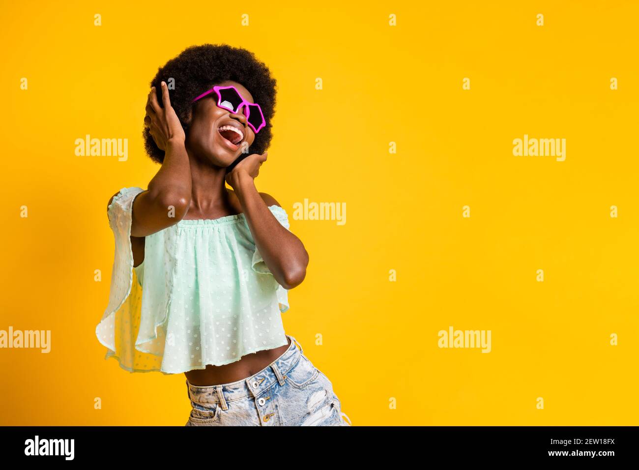 Photo portrait of black skinned girl dancing laughing wearing jeans shorts  teal top isolated on bright yellow color background copyspace Stock Photo -  Alamy