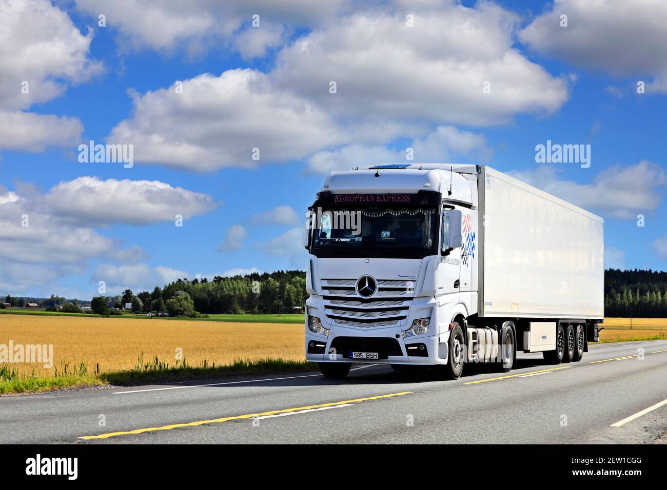 White Mercedes-Benz Actros 1845 truck pulls FRC semi trailer on highway 2 on a sunny day of summer.  Jokioinen, Finland. August 28, 2020. Stock Photo
