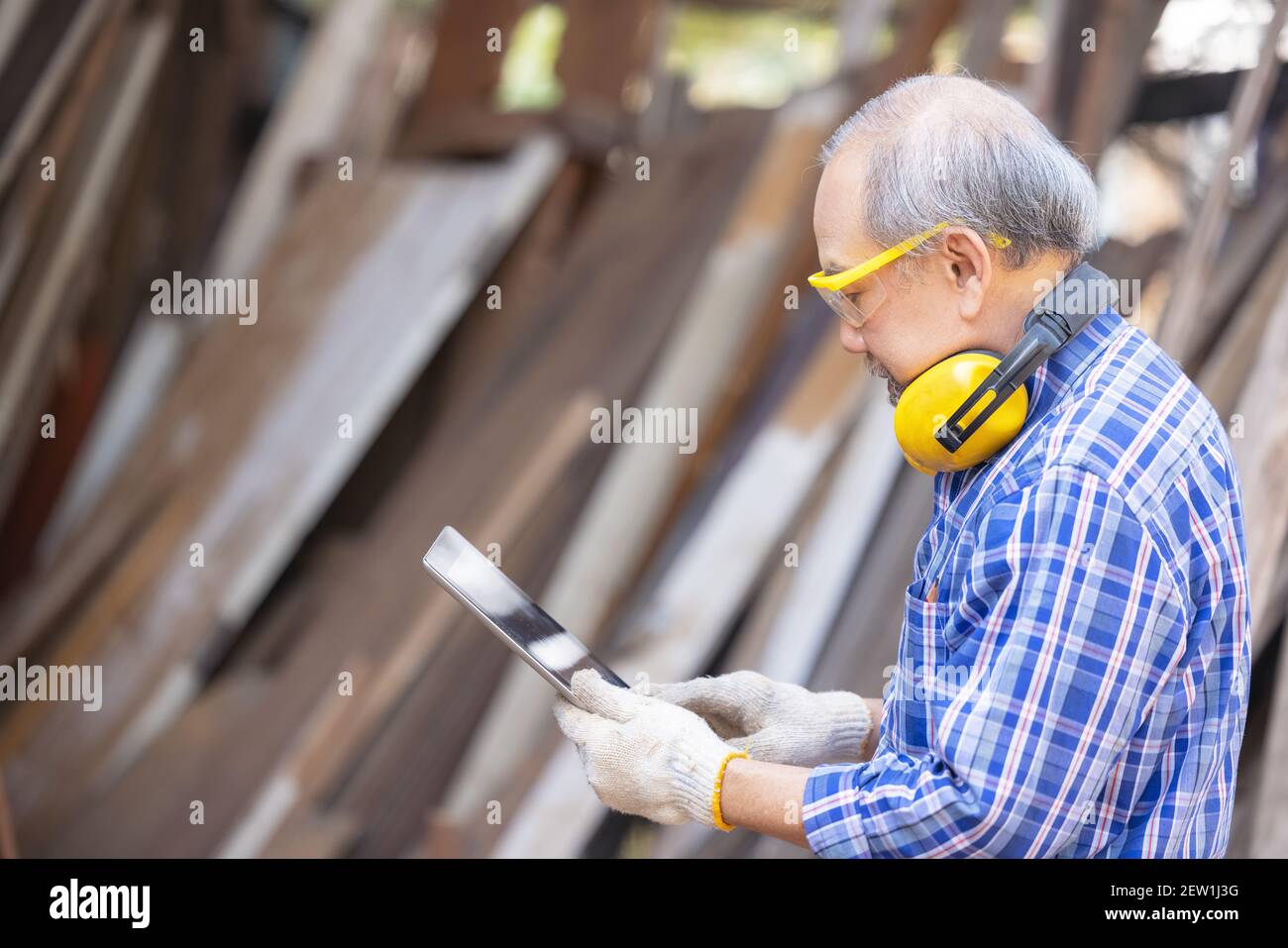 Male carpenter in a construction workshop, using a digital tablet Stock Photo