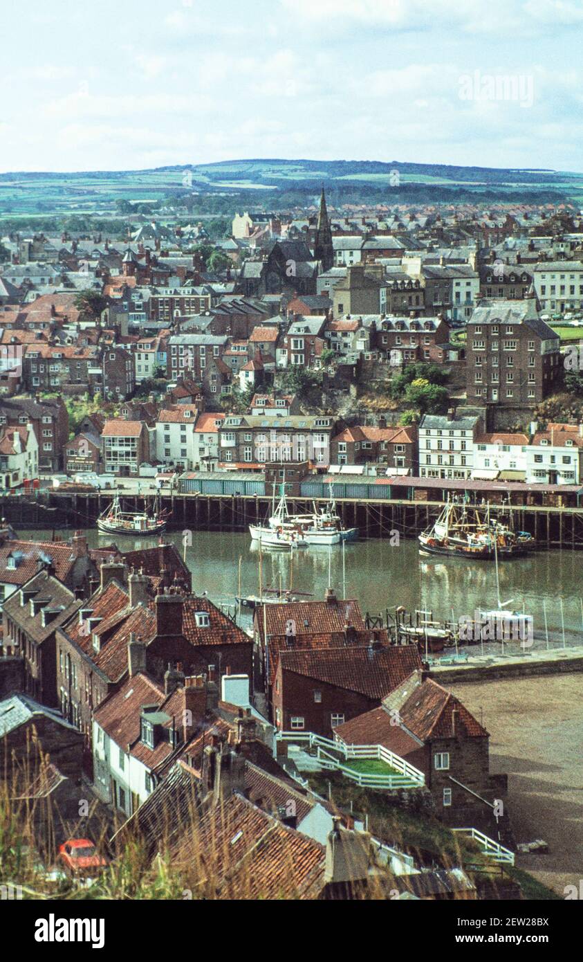 1978 - Whitby Yorkshire -  Whitby New town above the harbour with fishing boats at the quayside and fish dock and red roofs of the traditional houses of the Old Town Whitby North Yorkshire England UK GB Europe Stock Photo