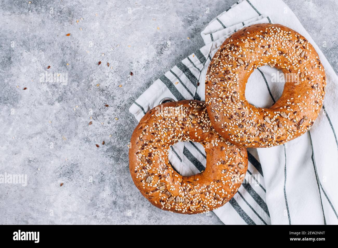 Healthy organic whole grain bagel on concrete background table. Breakfast bread. Copy space, top view Stock Photo
