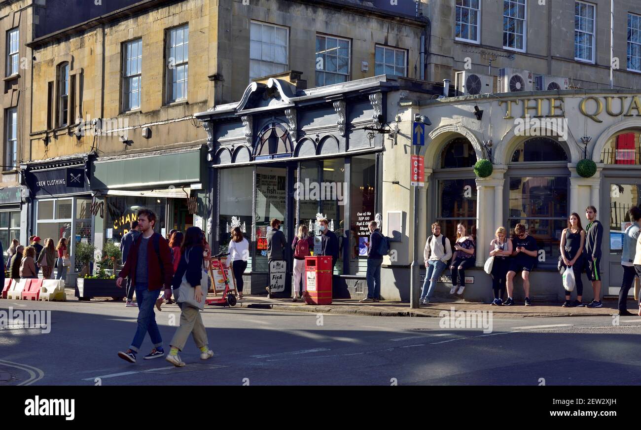 Queue of people lined up socially distancing waiting for fish and chips at local takeaway in Clifton, Bristol Stock Photo
