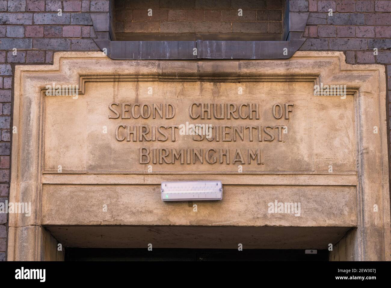 Stone sign above side entrance to the Second Church of Christ Scientist in Birmingham, UK, a grade 2 listed blue brick church Stock Photo