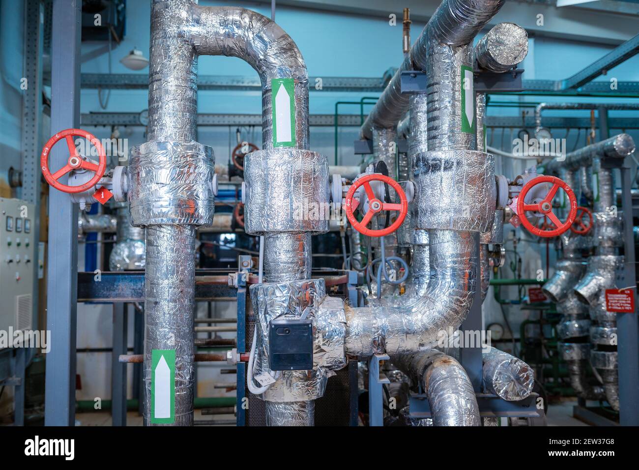 Industrial heating pipes. Red vents on the pipes. The concept of industrialization. Stock Photo