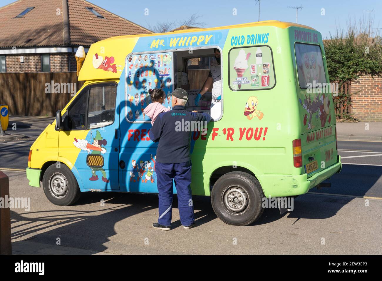 Man and his toddler order their ice cream from Mr Wihppy ice cream van