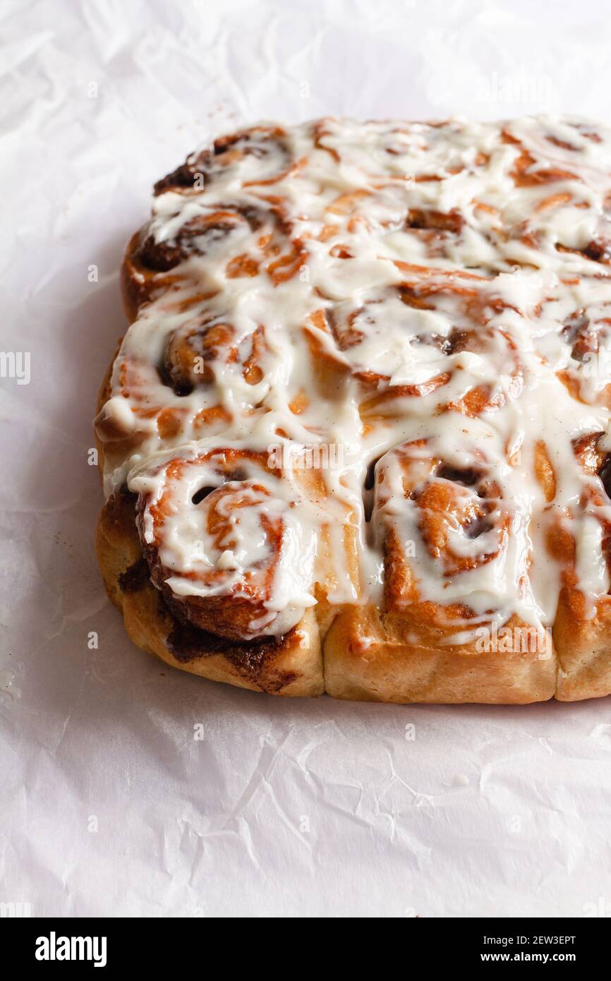 Freshly baked cinnamon rolls covered with a mascarpone cheese frosting. Stock Photo