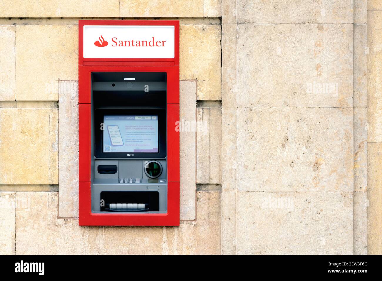 ATM machine of Bank Santander in the city.Detail of Santander office bank.Exterior view of Santander bank branch Stock Photo