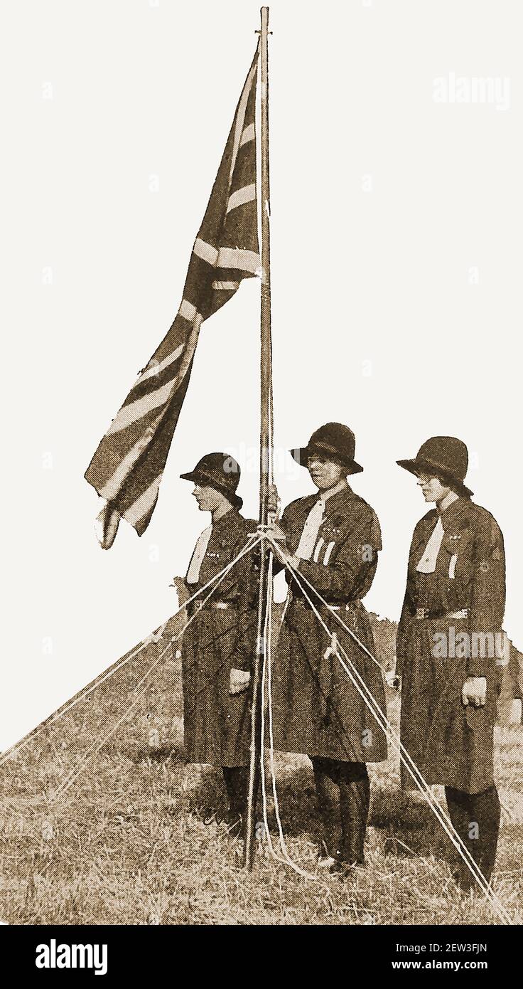 An early press photograph (circa 1940) of three British guides acting as the colour party at a Girl Guide Camp in Britain. Stock Photo