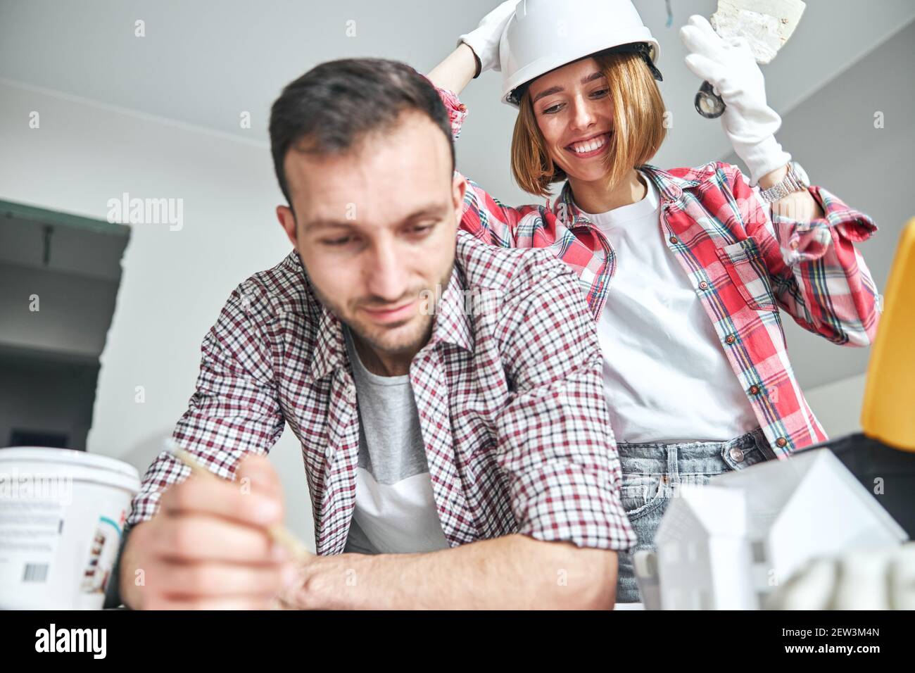 Workwoman watching a draftsman working at a building plan Stock Photo