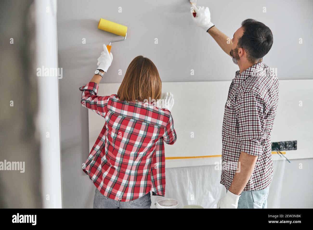 Two professional painters using a roller and a paintbrush Stock Photo