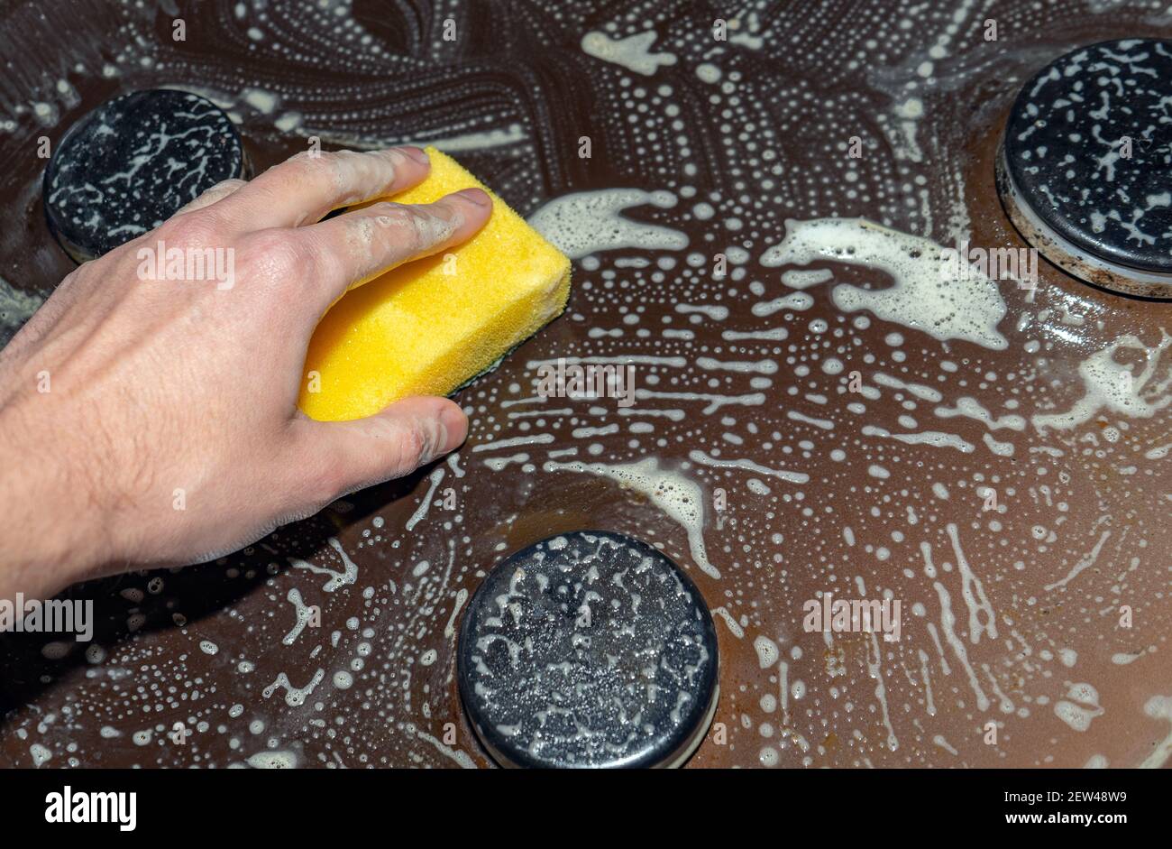Cleaning and washing the hob. Removing grease from a gas stove. Hand