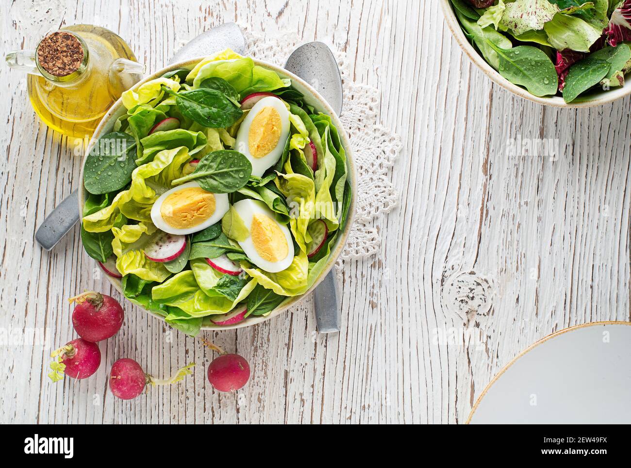 Healthy green salad with egg on wooden table background. Healthy meal. Stock Photo