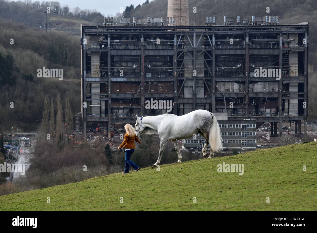 The cold ugly remains of Buildwas Power Station contrast with the natural beauty of the lady and her white Andalusian horse on the hills of the Severn Stock Photo