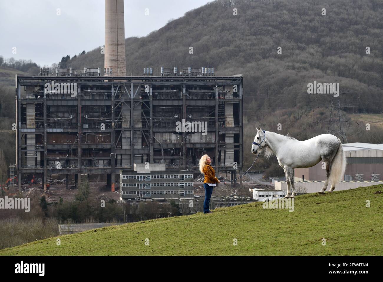 The cold ugly remains of Buildwas Power Station contrast with the natural beauty of the lady and her white Andalusian horse on the hills of the Severn Stock Photo