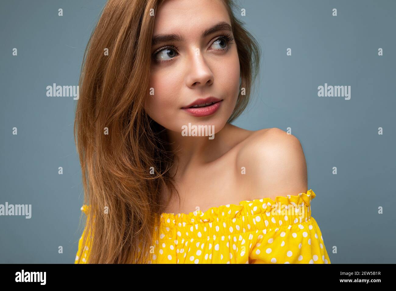 Closeup photo of young attractive dark blonde woman with sincere emotions isolated on background wall with copy space wearing stylish summer yellow Stock Photo