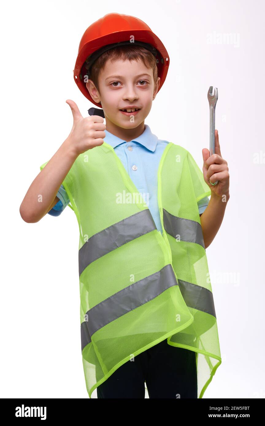 Preschool child construction vest in orange helmet holding wrench and