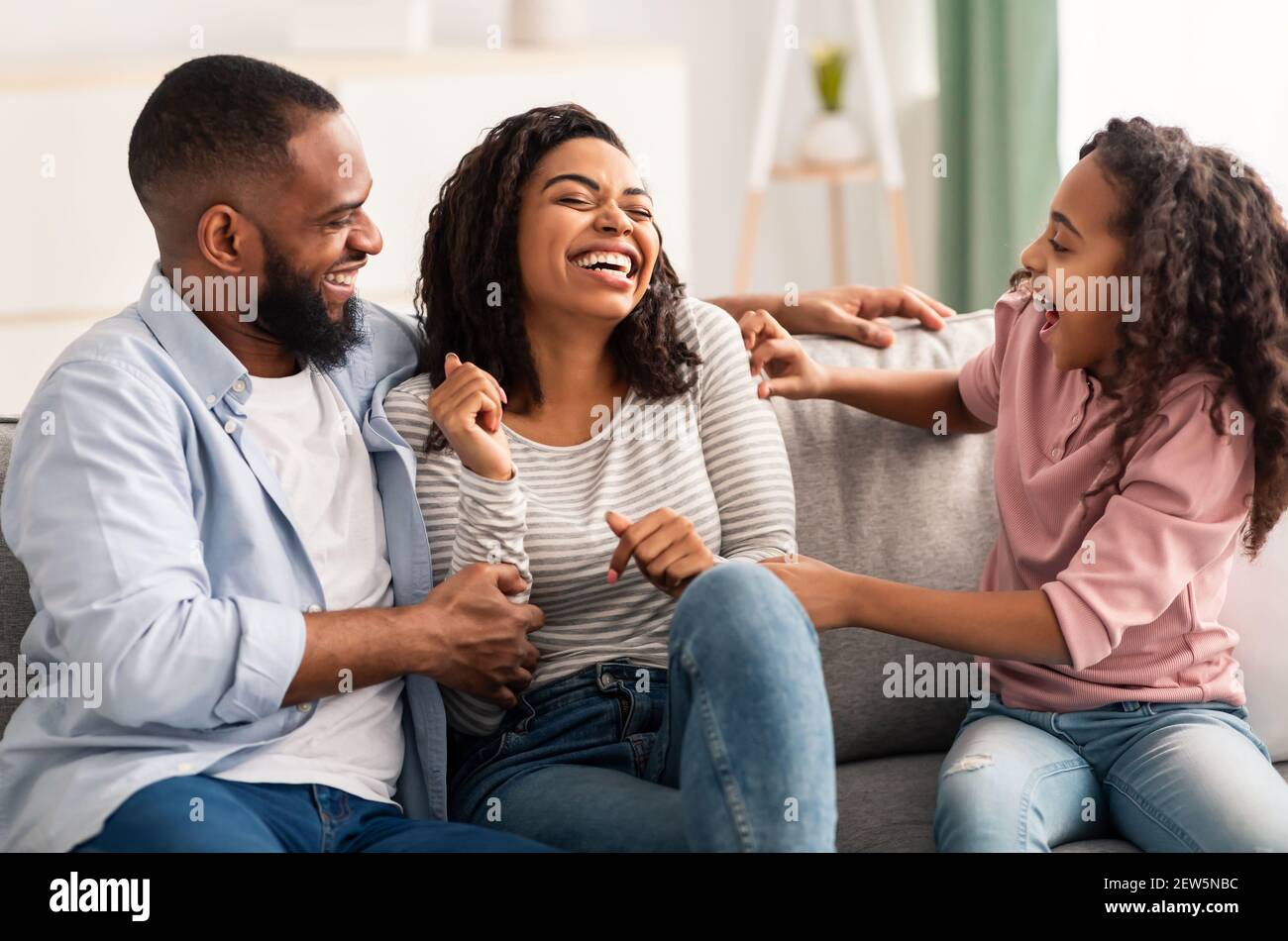 Portrait of a happy black family tickling at home Stock Photo