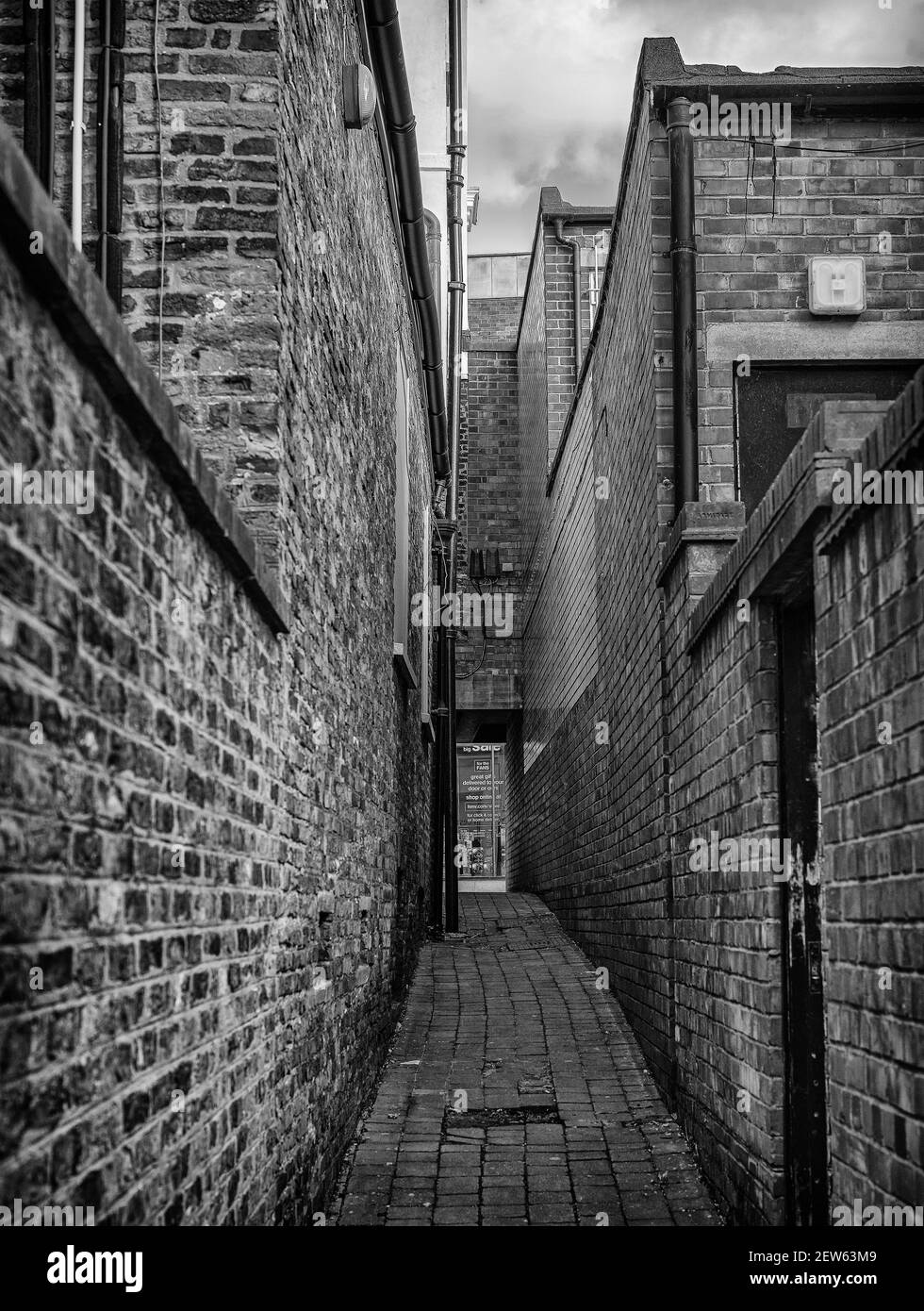 An Narrow Alleyway Leading To A Shopping Street The Buildings Each Side Are Made Of Red Brick And A Shop Is In The Background Stock Photo Alamy