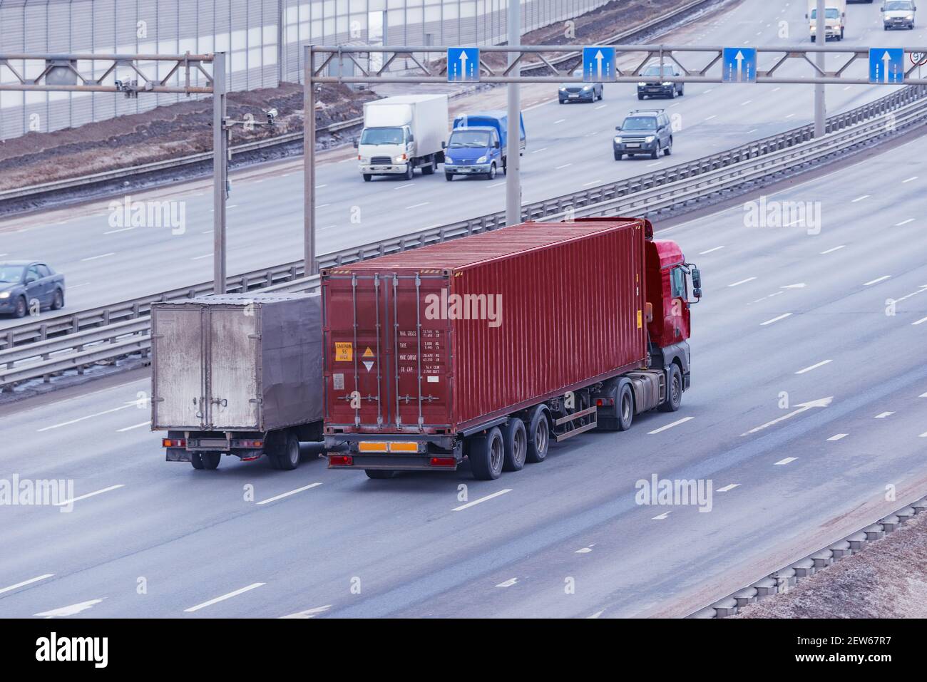 Freight trucks and passenger cars move on the modern highway Stock