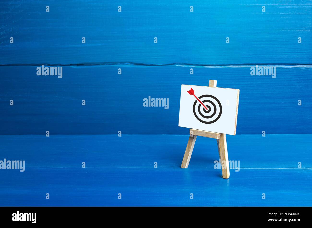 Easel with an arrow in target center. Direct hit, Bullseye, straight