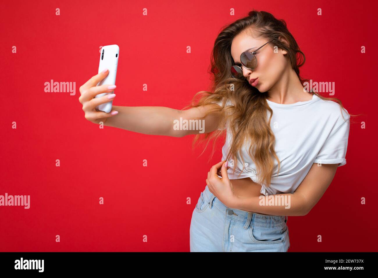 Closeup photo of amazing beautiful young blonde woman holding mobile ...