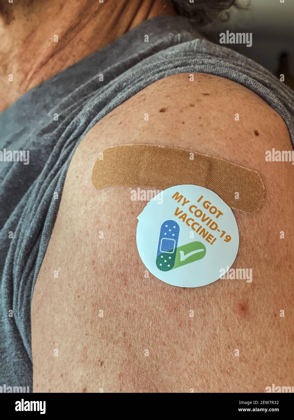 Senior adult man showing his adhesive covid-19 vaccination sticker. I got my COVID-19 vaccine. With bandaid. Stock Photo