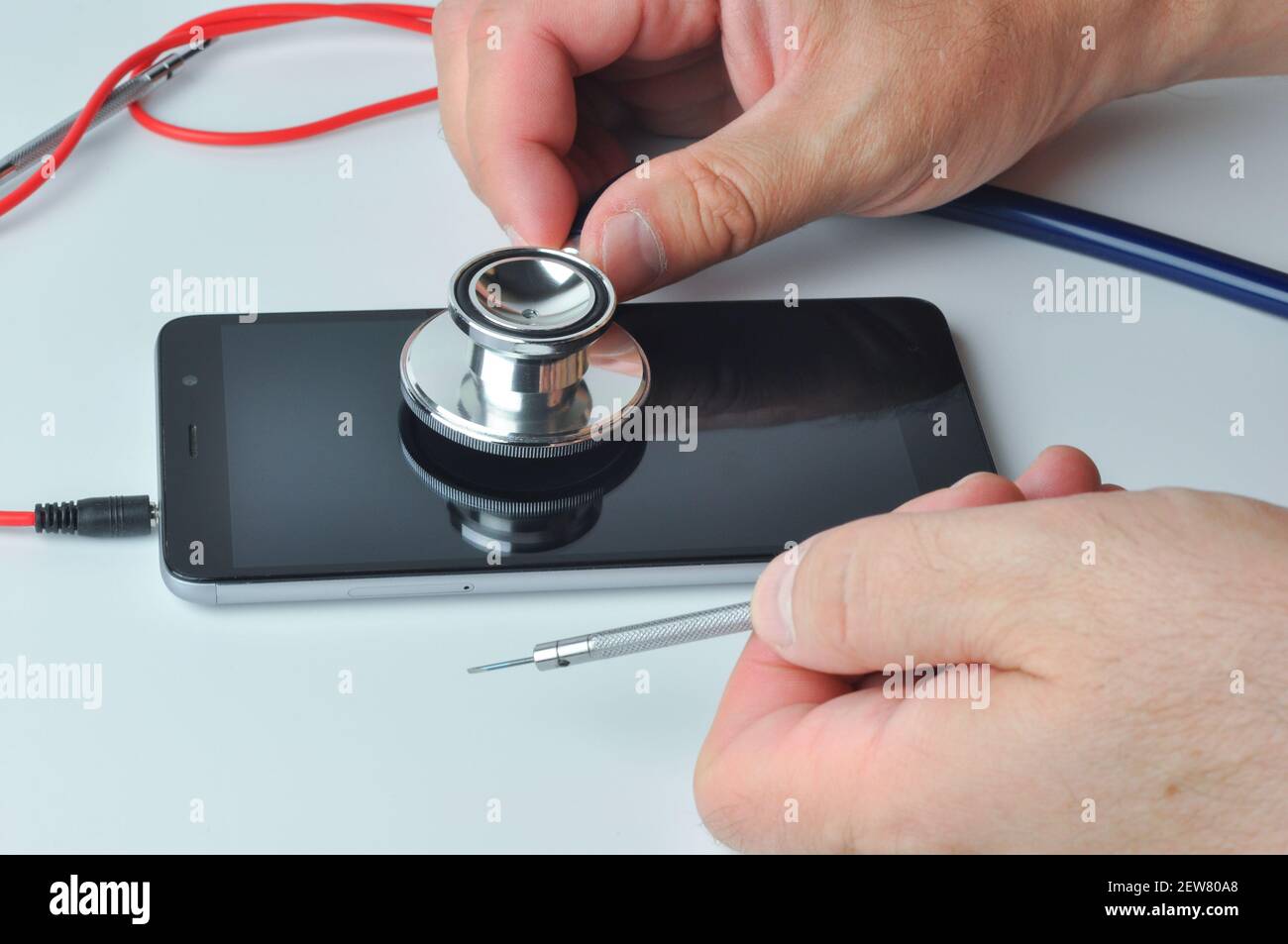 Men using a stethoscope for phone testing with empty copy space. Smartphone diagnostic, repair and service. Concept a health of device. Stock Photo