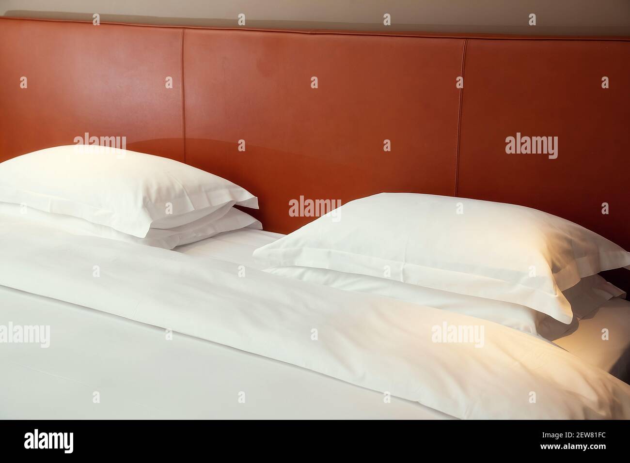 Typical hotel room. Double bed with white linen, two pillows Stock Photo