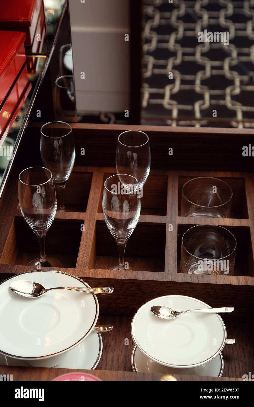 Pullout drawer filled with glass wine glasses, cups, saucers and