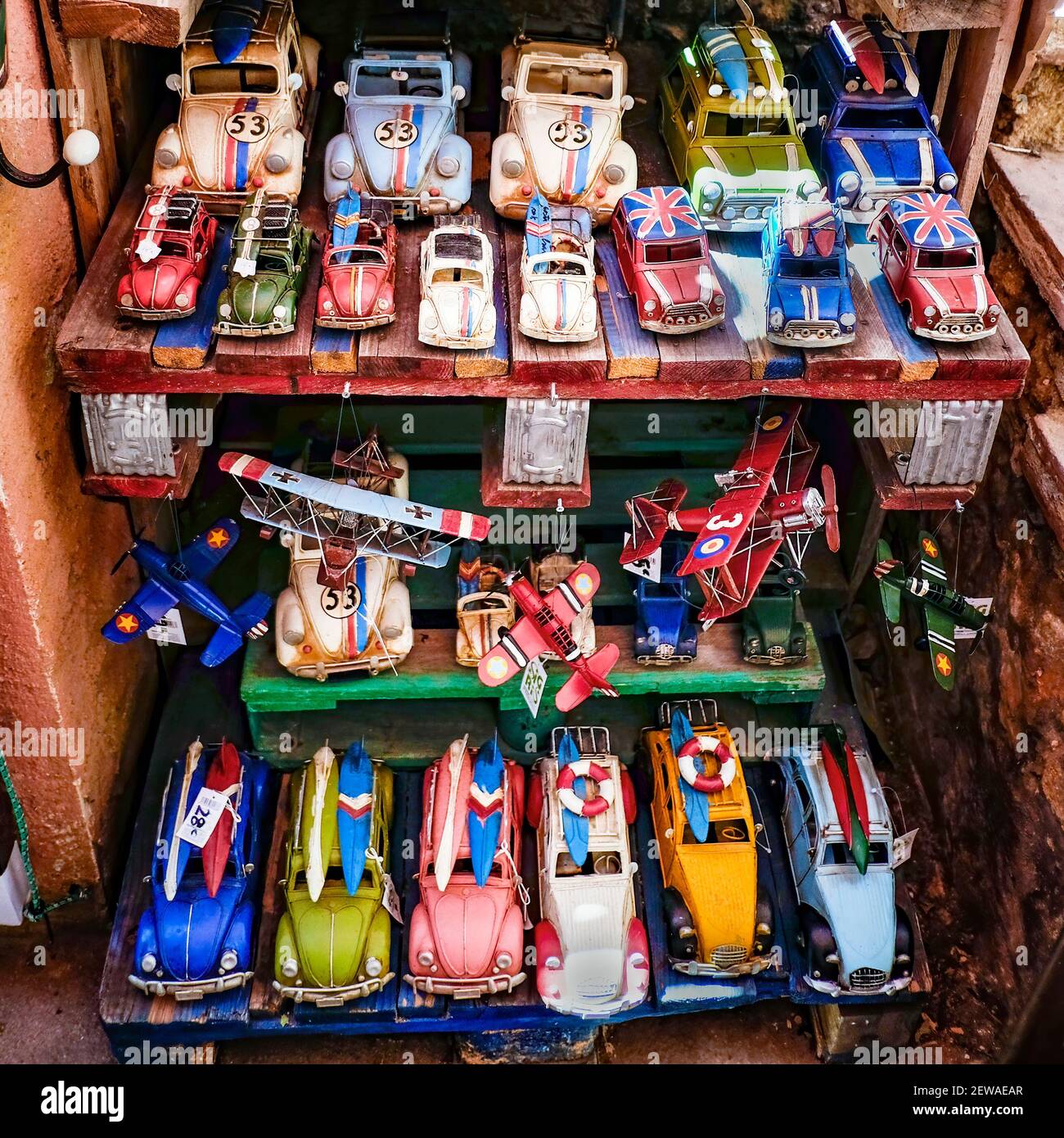 shelves of an artisan toy store with vintage classic cars with hippie aesthetics, English flags and surfboards, airplanes of the first world war, squa Stock Photo