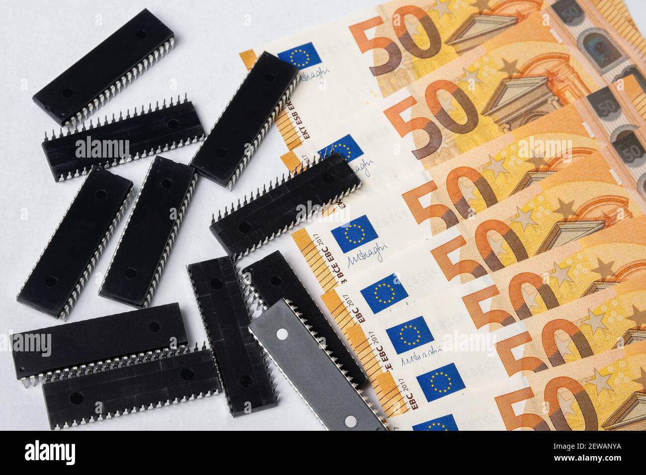 Semiconductor chips shortage and high price. Pile of computer chips and spread of  Euro banknotes. Concept for crisis in the industry. Stock Photo