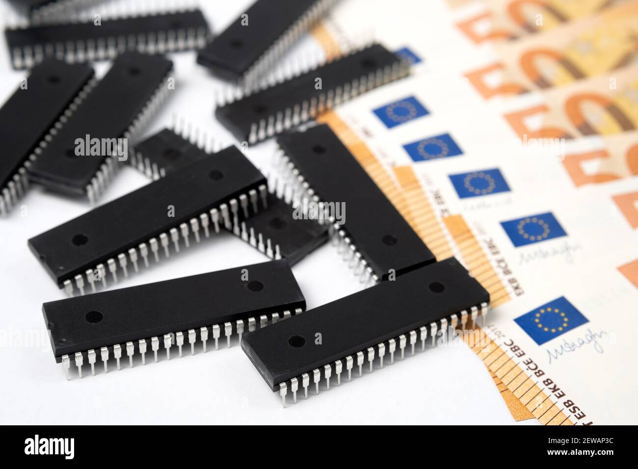 Semiconductor chips shortage and high price. Pile of computer chips and spread of  Euro banknotes. Concept for crisis in the industry. Stock Photo