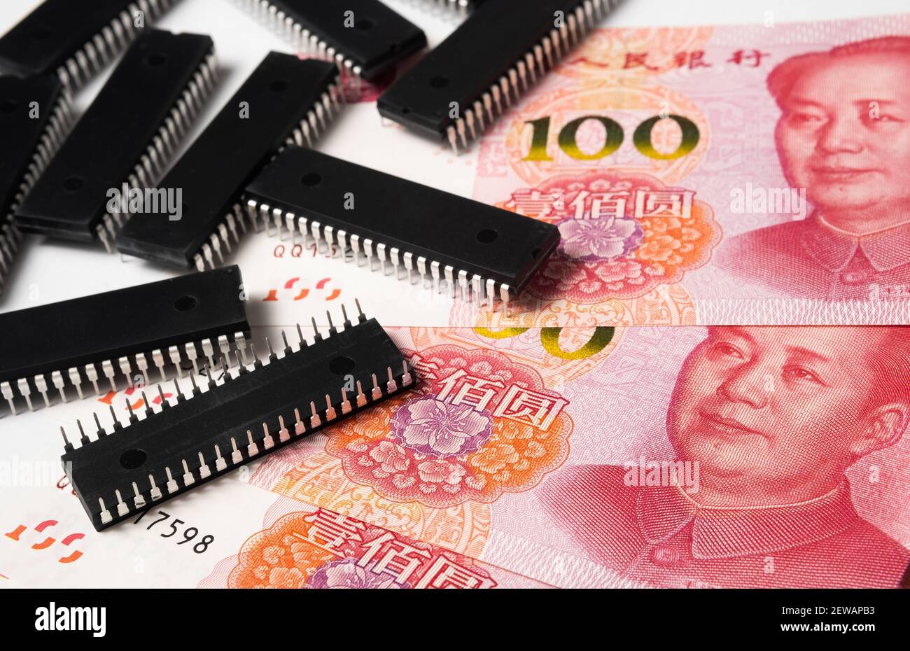 Semiconductor chips shortage and high price. Pile of computer chips and spread of  Chinese Yuan banknotes. Concept for crisis in the industry. Stock Photo