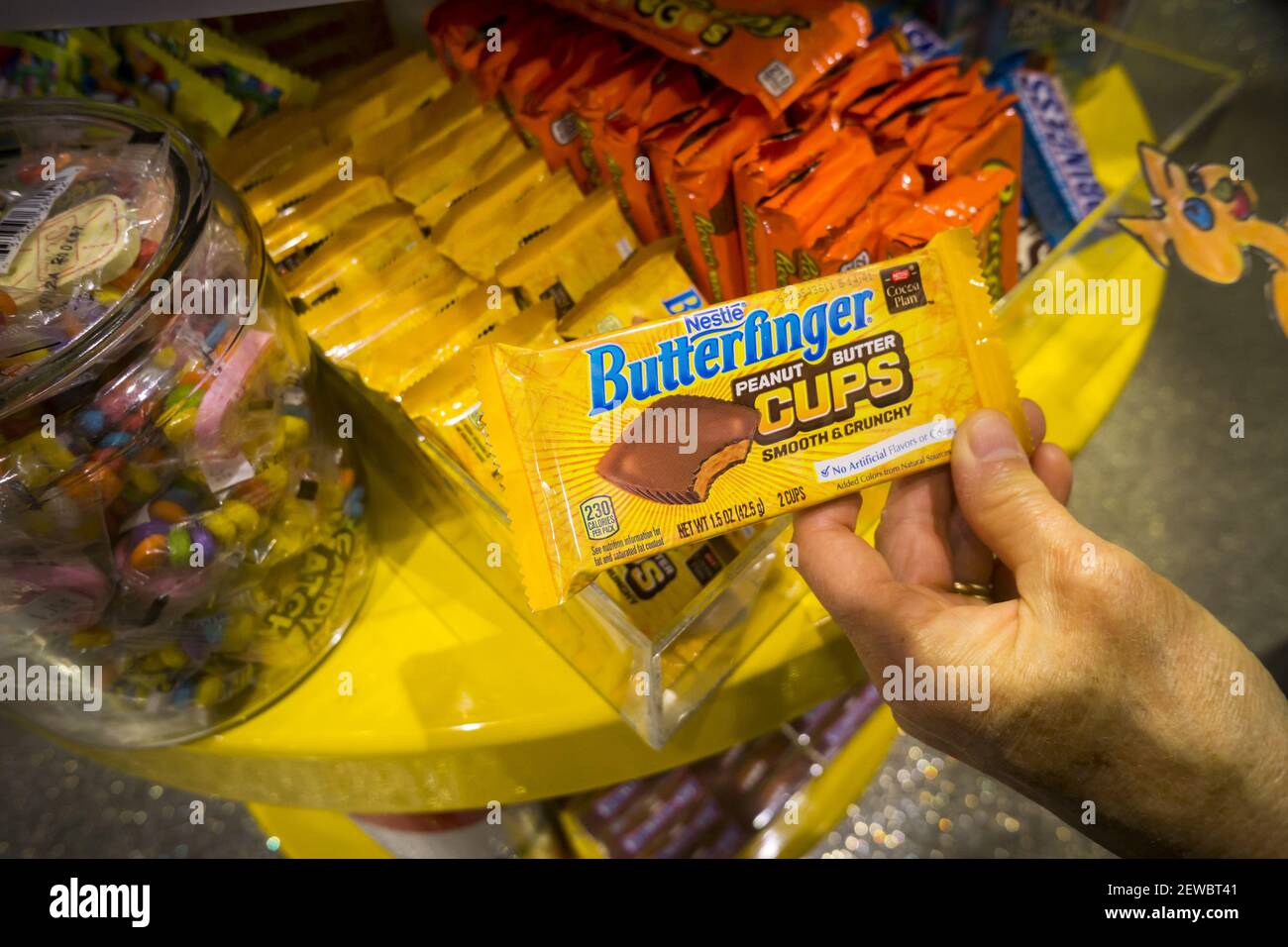 A shopper chooses a Nestlé's brand Butterfinger candy in a store in New York on Tuesday, September 5, 2017. Nestlé is reported to be very near in picking the buyer for its U.S. chocolate business with Ferrero, the maker of Nutella, reported as front-runner. (Photo by Richard B. Levine) Stock Photo