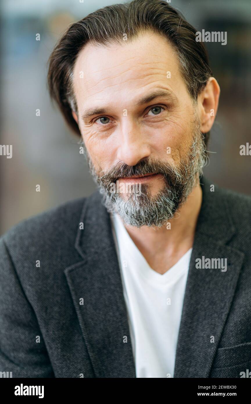Close-up portrait of mature influential male in stylish suit. Serious grey-haired businessman looking directly at the camera, showing self confidence and success Stock Photo