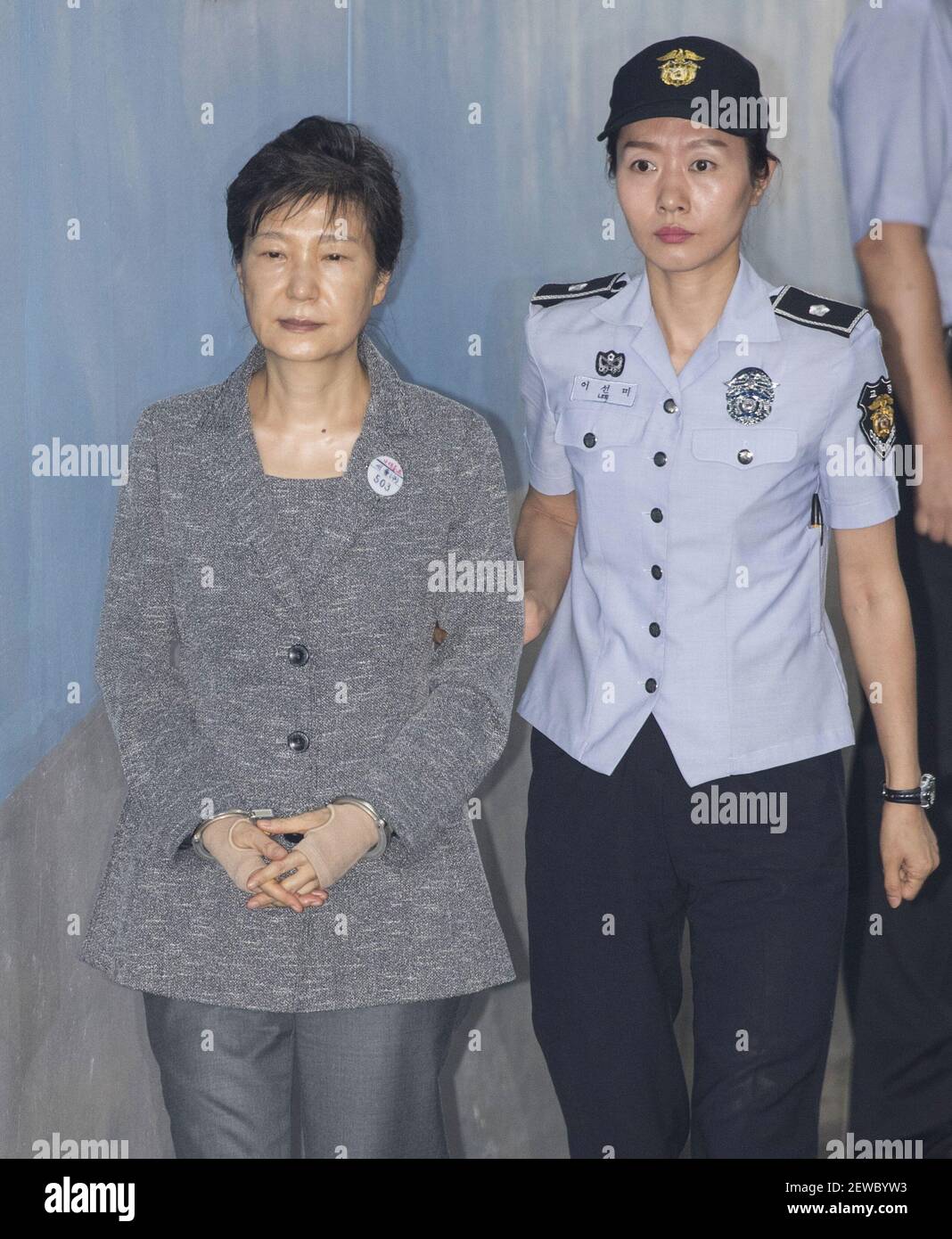 25 August 2017 - Seoul, South Korea : Park Geun-hye, former president of South Korea, (Left), is escorted by proson officer as she arrives at the Seoul Central District Court in Seoul, South Korea on August 25, 2017. Samsungs de facto leader Jay Y. Lee will lean hia fate Friday in a trial that has gripped the nation for six months as part of a wider scandal involving former Park. Photo Credit: Lee Young-ho Stock Photo