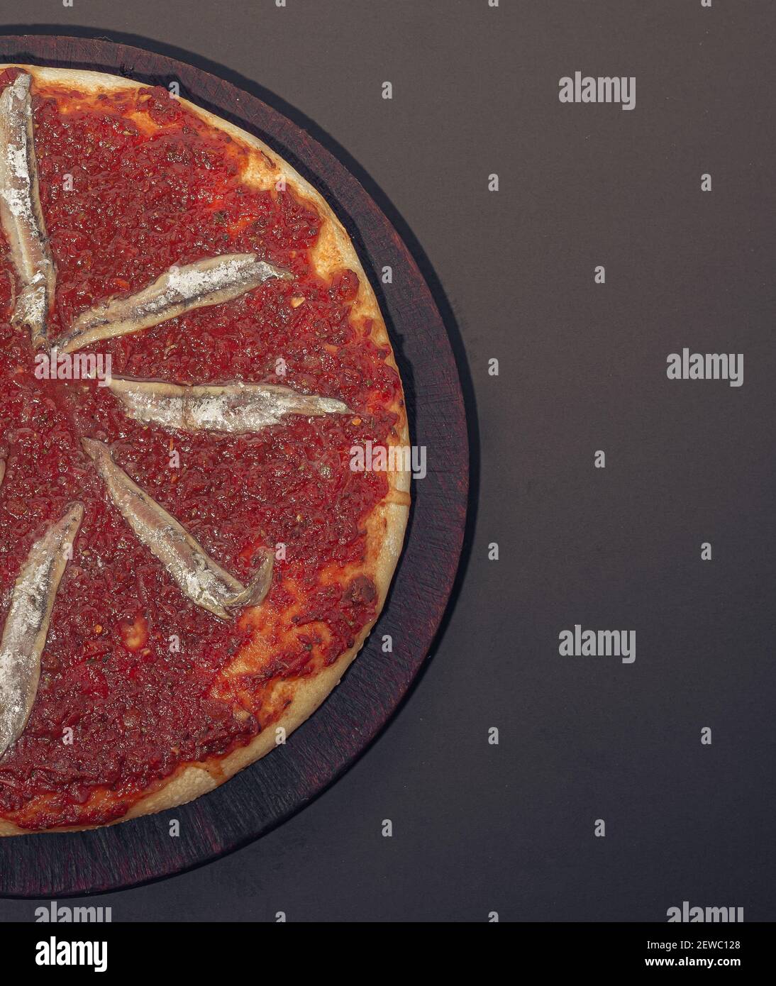 Home made anchovies italian Pizza tomate sauce. Black background Stock
