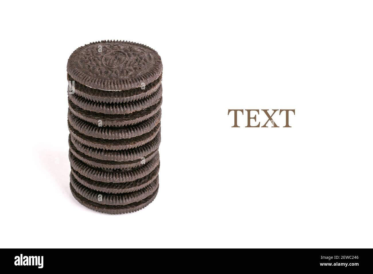 Chocolate black thin cookie with white filling, delicious milk sweet cookie scattered on a white background. Stock Photo