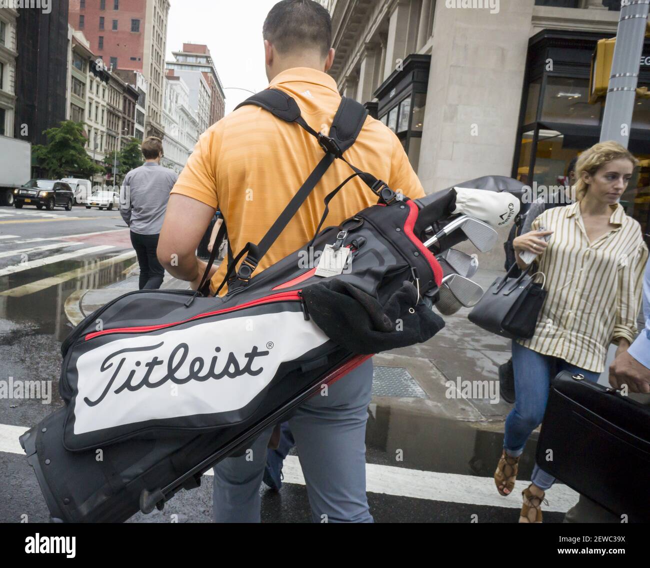 A golfer walks in New York with his collection of Acushnet brands ...