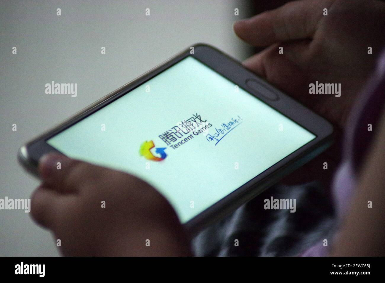 FILE--A Chinese mobile game player plays Tencent's multiplayer online  battle royale game PlayerUnknown's Battlegrounds, on his smartphone in  Ji'nan city, east China's Shandong province, 2 July 2017. China's biggest game  developers including