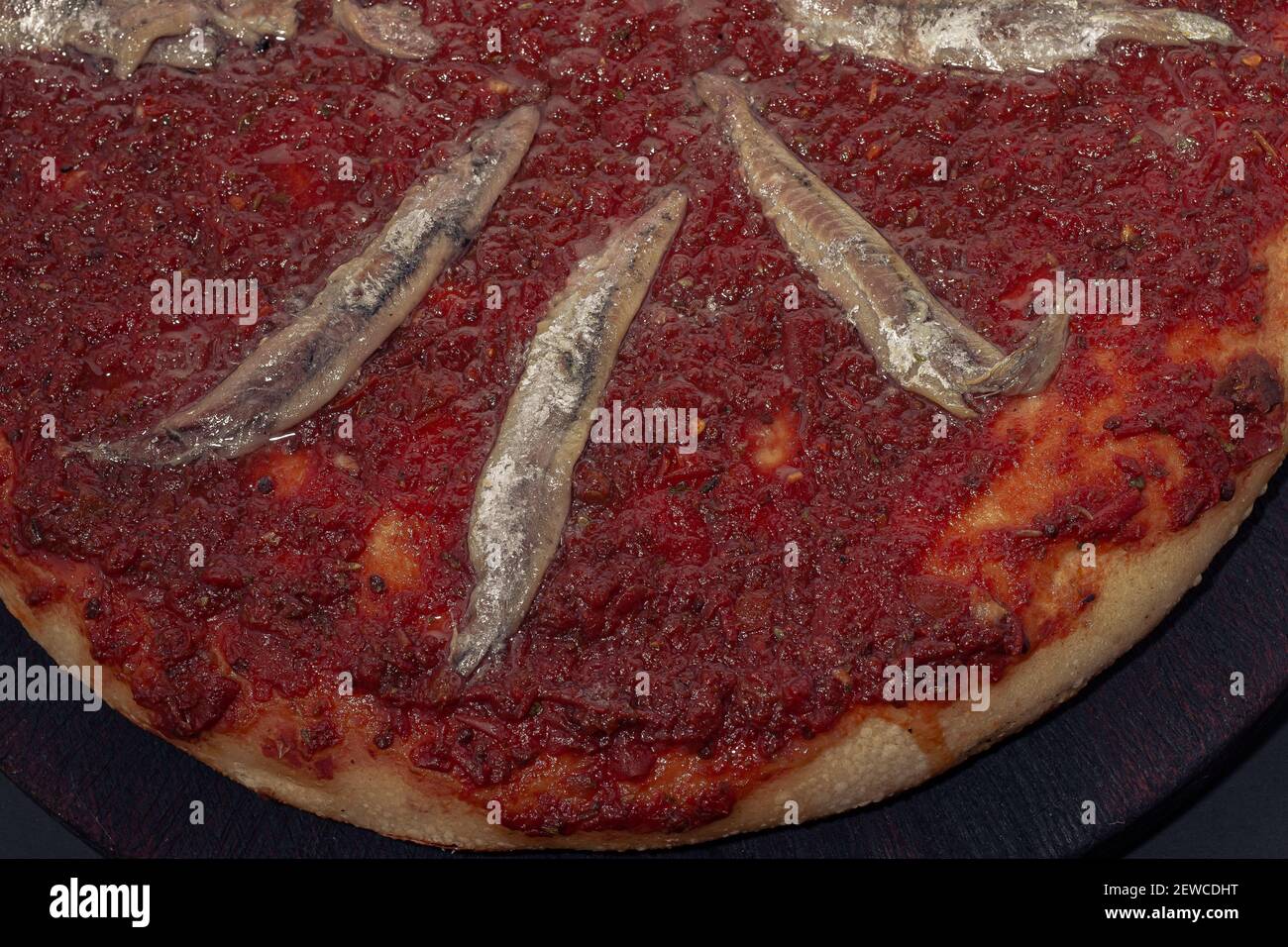 Home made anchovies italian Pizza tomate sauce. Black background Stock