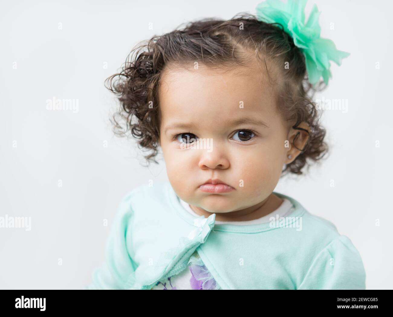 A little girl with a serious, pouting facial expression. Stock Photo