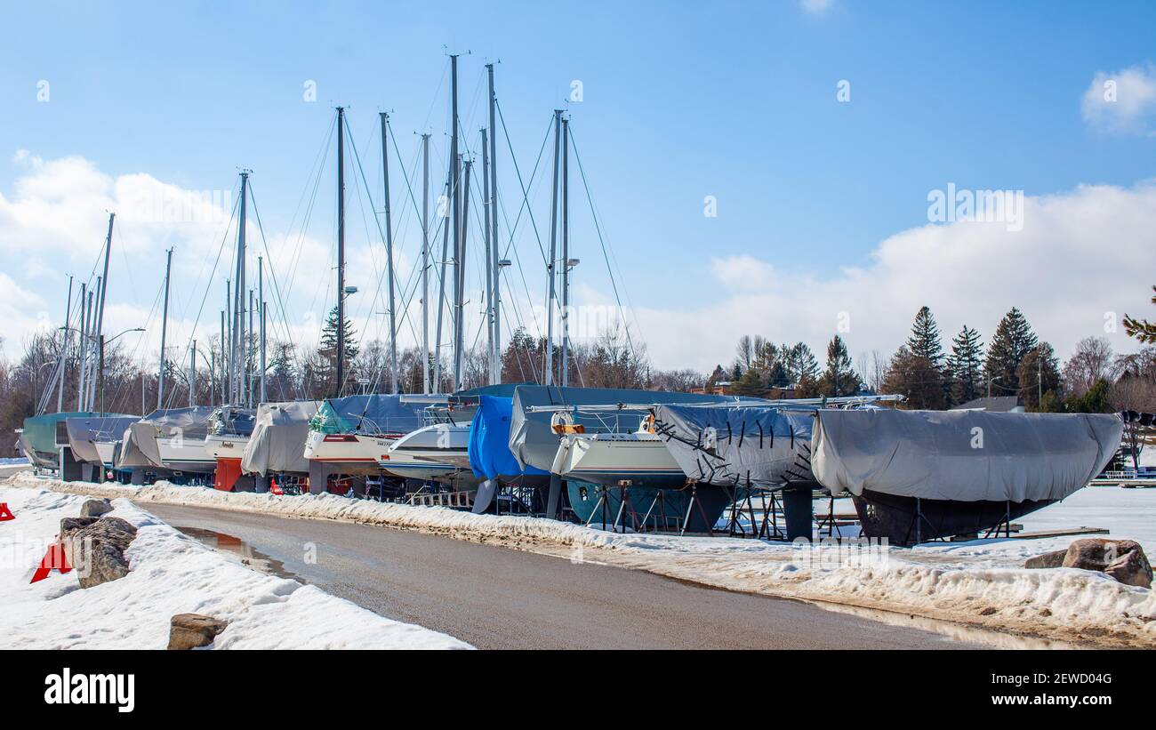 Sailboats line the perimeter of the Thornbury Yacht Club during the winter months when the harbor is frozen. The boats are winterized and covered up. Stock Photo