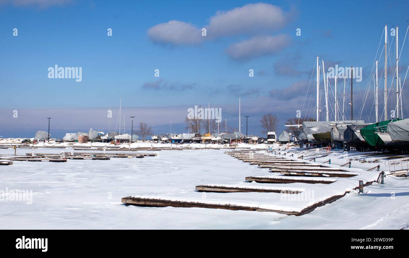 Sailboats line the perimeter of the Thornbury Yacht Club during the winter months when the harbor is frozen. The boats are winterized and covered up. Stock Photo